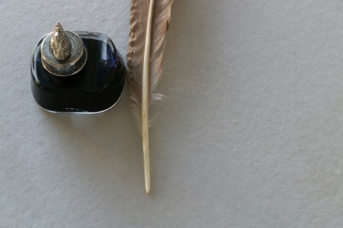 Quill and ink pot on a white background